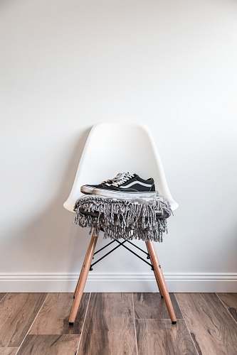 interior pair of black low-top Vans sneakers on white chair furniture