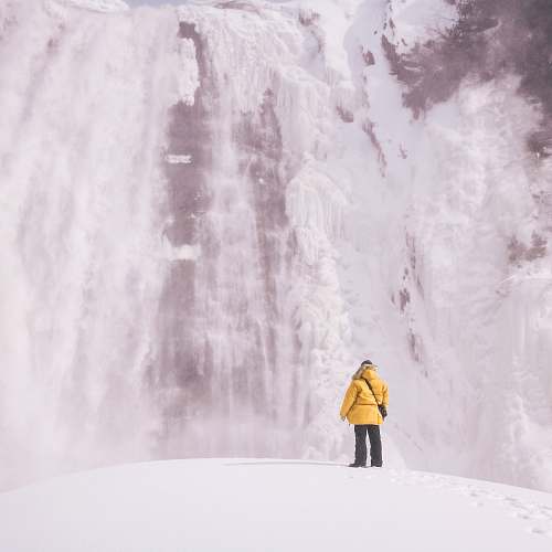 apparel person standing front of waterfalls coat