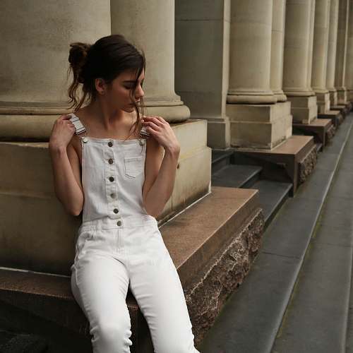 apparel woman sitting and leaning on wall human