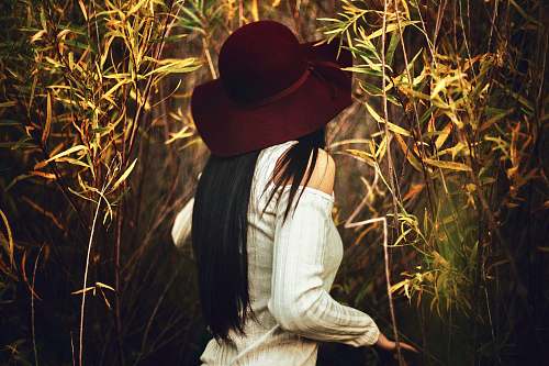 hat woman standing in between plants cowboy hat