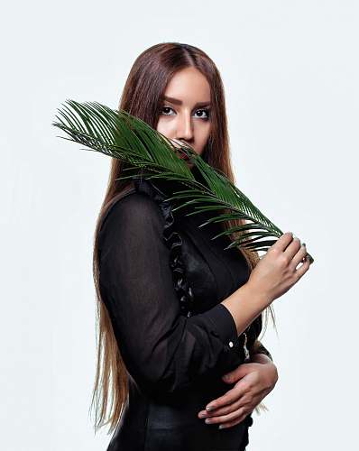 apparel woman wearing black long-sleeved shirt holding leaf female