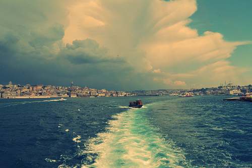 water boat on body of water under cloudy blue sky sea