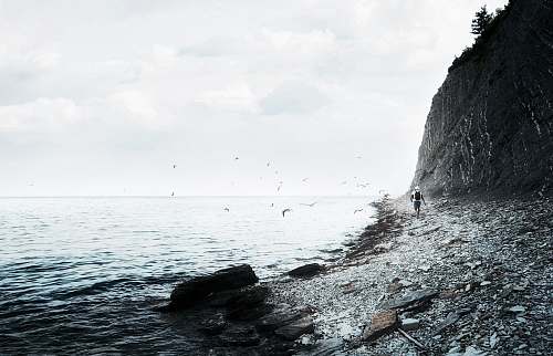 ocean person walking near seashore during daytime sea