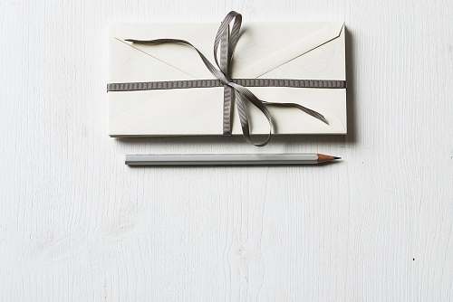 minimal white envelop and gray pencil on white panel white