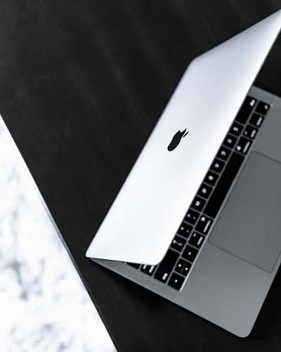 game opened silver MacBook on black wooden surface white