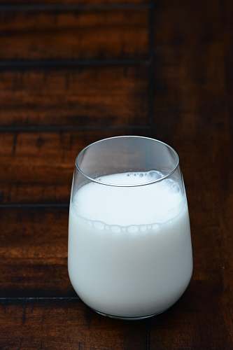 white clear drinking glass with white liquid milk