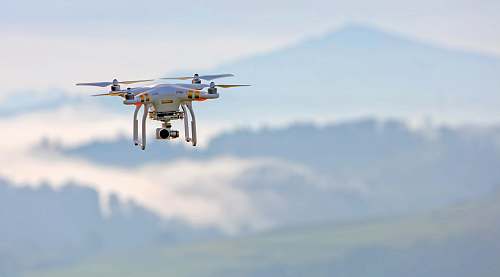 biplane shallow focus photo of white quadcopter transportation
