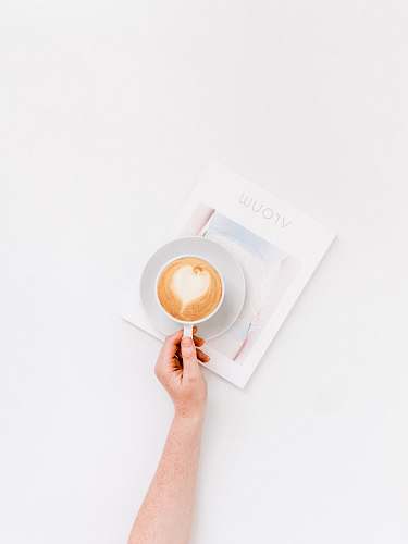 food person holding white ceramic mug reading