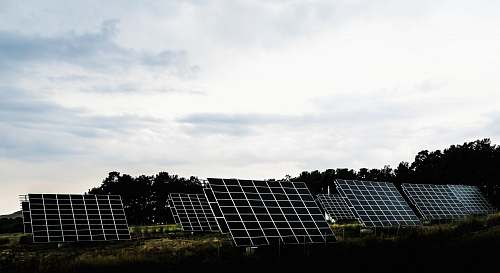 greece silhouette photography of assorted solar panel behind trees solar
