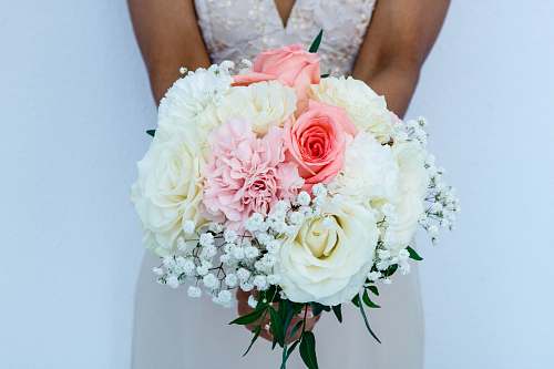 rose woman wearing white sleeveless wedding dress holding flower bouquet blossom