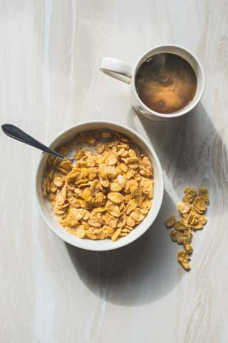 breakfast ceramic bowl filled with cereals and spoon bowl