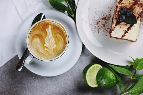 coffee flat lay photography of coffee in teacup near plate of sliced cake lime