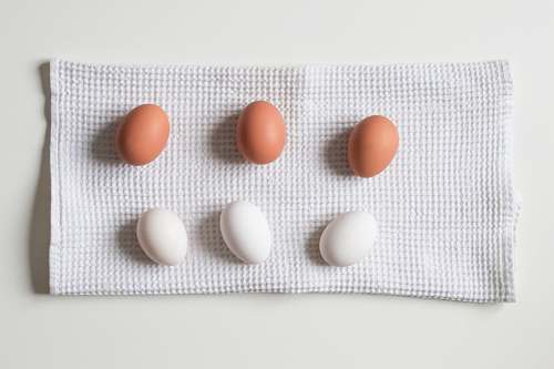 medication six white and brown eggs on white towel pill