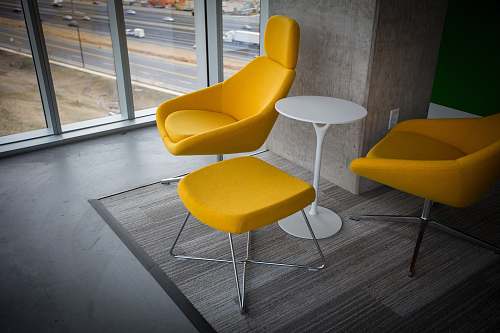 chair room with yellow fabric chairs and ottoman with table yellow