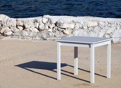 table square white wooden table on dirt ground tabletop