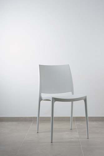 chair white armless chair near white wall blue