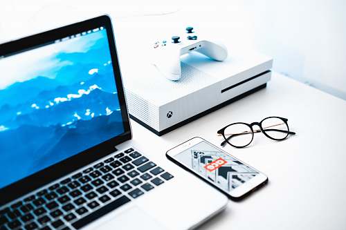computer turned on MacBook Pro beside iPhone and Xbox One Slim laptop