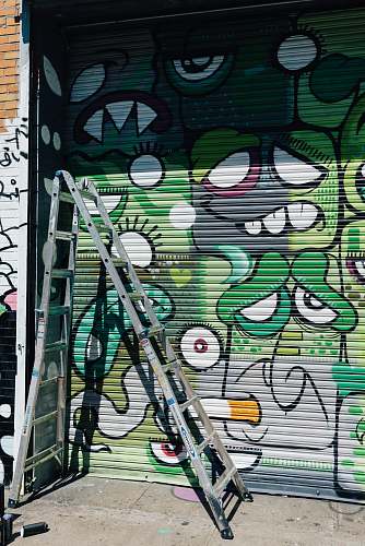 art gray multi-position ladder on front of painted roller shutter mural