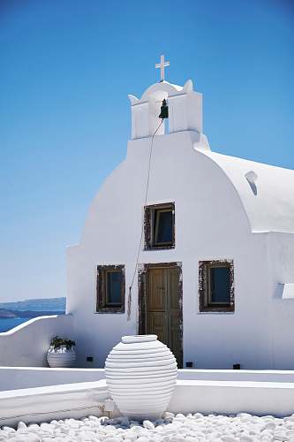 cross white concrete chapel oia