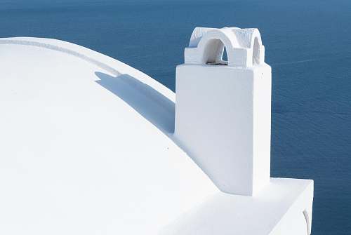 alphabet white structure near body of water during daytime text