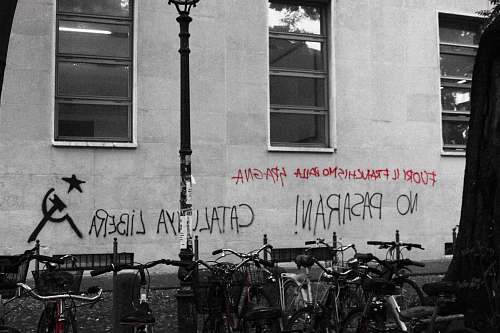 bike black and red text vandals on wall near parked bicycle italy