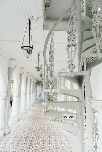 corridor brown and white pendant lamp near white spiral stairs in hallway spiral