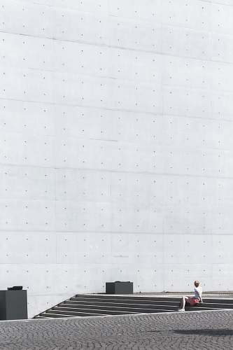 germany man sitting on gray concrete stairs during daytime berlin