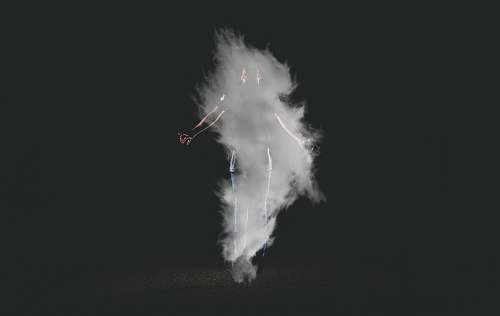 black-and-white person standing near smoke with black background night