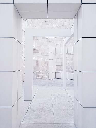 white photo of empty arch hallway path
