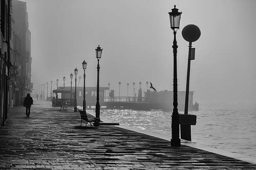 black-and-white silhouette person walking at walkway italy