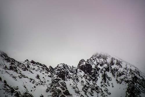 snow snow covered mountain under gray cloudy sky mountain