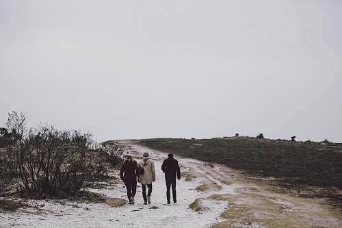 walking three person walking on snow covered field friends