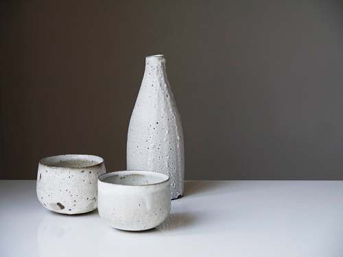 sake two white ceramic bowls and bottle on white table beverage