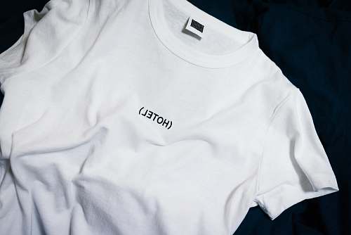 human white hotel-printed crew-neck shirt on black surface person