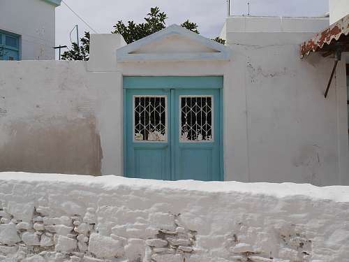 paros white house with blue double-door gate greece