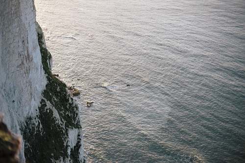 water white rocky mountain next to ocean ripple