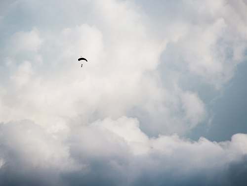 cloud worms eye view photography of person paragliding sky