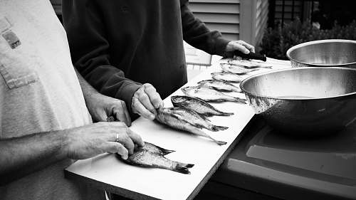 black-and-white grayscale photography of two people in front of fish on table fish