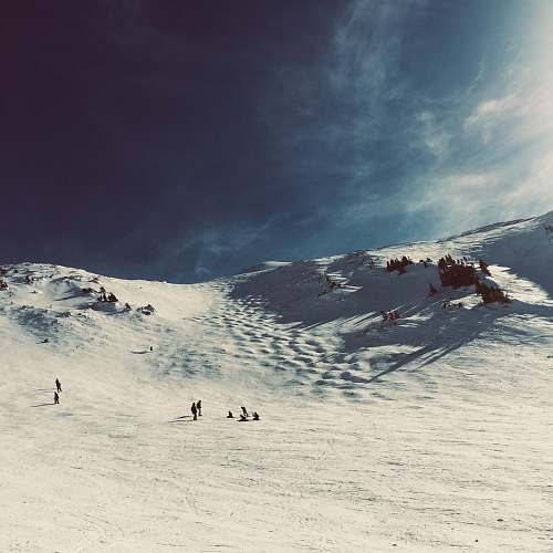 nature group of people at middle of field covered with snow under clear blue sky outdoors