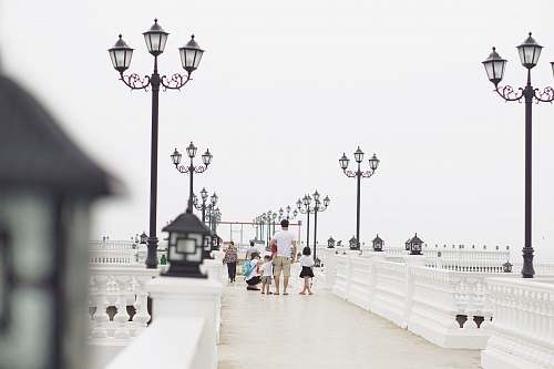 person man holding children walking near white light post white