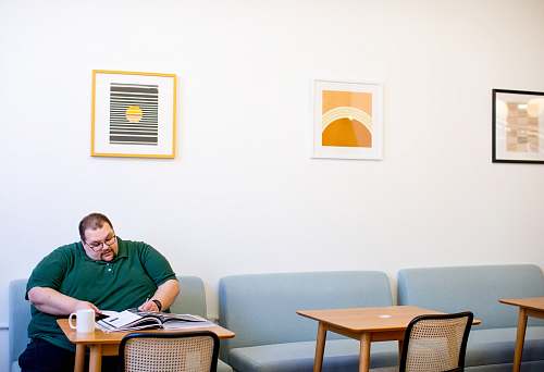 person man sitting on sofa wrting on paper chair