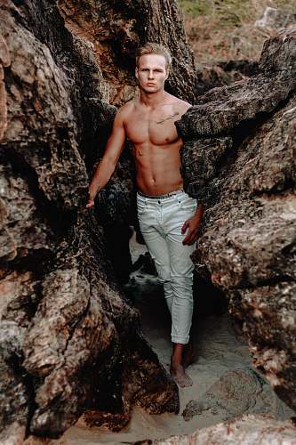 person man standing between brown rock formation during day time people
