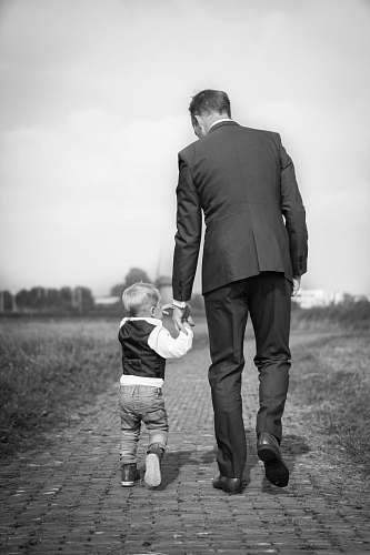 black-and-white man walking holding boy people