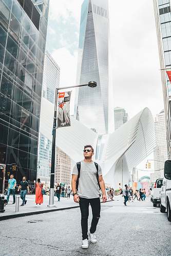 person people standing near city with high-rise buildings under white and blue sky during daytime pedestrian