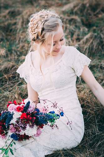 person woman holding bouquet of flowers siting on hay people