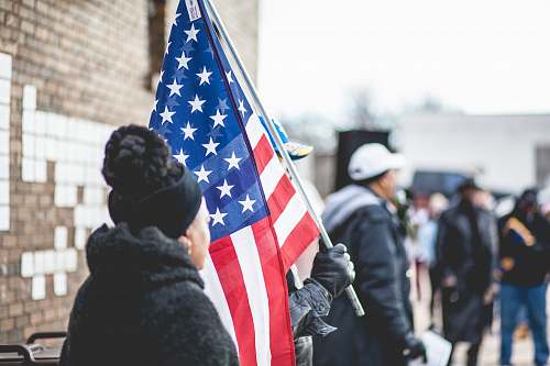 person woman standing beside person holding flag of America people