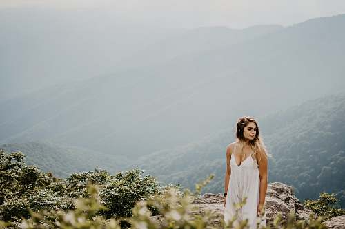 people woman standing on brown rocky terrain at high altitude person