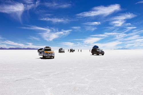desert sports utility vehicles on desert under cloudy blue sky during daytime uyuni