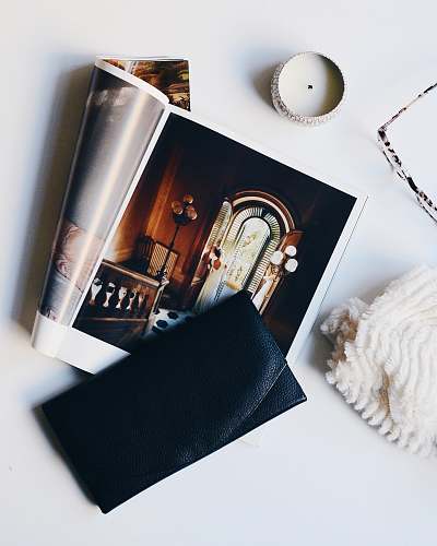 candle black leather purse on magazine page from above