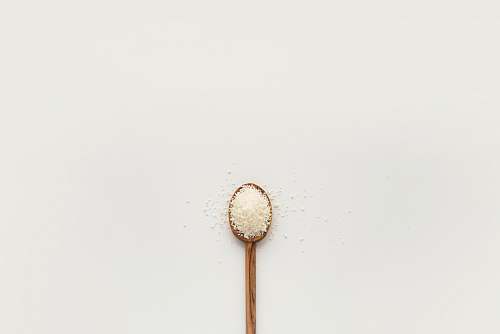 food white powder on brown wooden spoon spoon